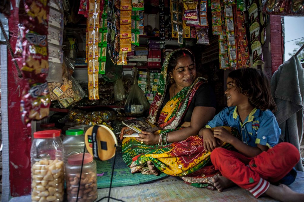 A woman and child lit with solar light in India