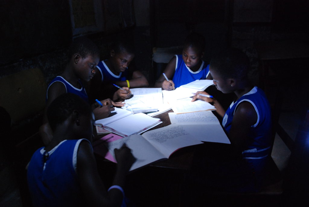 This same group of children now study with the help of a bright solar lantern.
