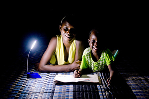 Children read a school book with a solar lamp in Dakar, Senegal.© Bruno Déméocq/Lighting Africa 