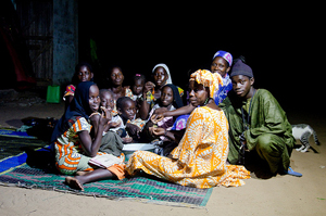Better lights for better lives: here, a group of people eating under the light of a solar lamp, Senegal. © Bruno Déméocq/Lighting Africa/2012. 