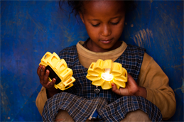 An Ethiopian child admires the Little Sun lamp © Merklit Mersha /2012 Little Sun